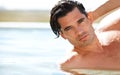 You can see the confidence in his chiseled face. Portrait of a sexy young man in a swimming pool running his hand Royalty Free Stock Photo