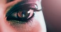 You can see the fire burning through her eyes. Closeup shot of a beautiful young womans eye against a dark background. Royalty Free Stock Photo