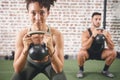 You can talk the talk but can you lift. two sporty young people using kettlebells while working out at the gym. Royalty Free Stock Photo