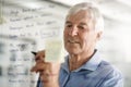 You cannot be a great businessman without planning. a senior businessman writing down ideas with a pen marker on a glass