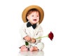 Smiling one old year boy in retro, bow-tie hat and with red rose sitting on white background. Royalty Free Stock Photo