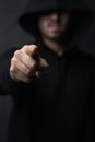 You could be next. an unidentifiable hooded man pointing while standing against a dark background. Royalty Free Stock Photo