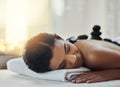 You deserve this break. a young woman getting a hot stone massage at a spa. Royalty Free Stock Photo