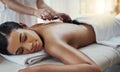 You deserve this full body massage. a young woman getting a hot stone massage at a spa. Royalty Free Stock Photo