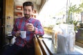 Because you deserve a good cup of coffee. a young man pointing at you while holding a cup of coffee in a coffee shop. Royalty Free Stock Photo