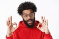 You doing great. Satisfied and delighted outgoing african american bearded man in glasses with afro hairstyle wearing