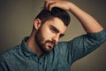 You dont choose the beard the beard chooses you. Studio shot of a handsome young man posing with his hand in hair.