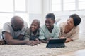 You dont choose your family. They are Gods gift. a family using s tablet while laying on the floor at home. Royalty Free Stock Photo