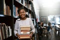 You dont have to look far to find the answers. Portrait of a happy young woman carrying books in a library at college. Royalty Free Stock Photo