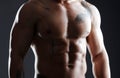 You dont tell people youre a gym fanatic, they see it. an athletic young man posing shirtless against a dark background.