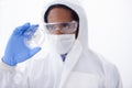 You dont wanna mess with this virus. a male scientist in a biohazard suit holding a petri dish.