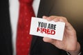 You are fired message on business card shown by a businessman. Labour force crisis Business risk management concept