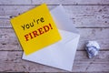 You are fired text on yellow notepad with envelope background. Royalty Free Stock Photo