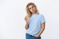 You are good, not bad at all. Portrait of impressed and proud cool swag young girl with short blond curly hair frown and