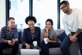 You guys have to see this. a group of colleagues having an informal meeting on a sofa at work. Royalty Free Stock Photo