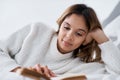 When you have some free time, read. a young woman reading a book while lying on her bed. Royalty Free Stock Photo