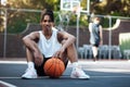 You have to show confidence on the court. Portrait of a sporty young man sitting on a basketball court.