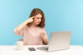 You are idiot! Angry woman at workplace making stupid gesture and pointing to laptop screen, having silly senseless talk