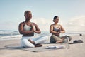 You inspired me to tap into my inner yogi. two young women meditating during their yoga routine on the beach.