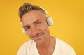 Are you listening closely. Middle-aged man wear headphones yellow background. English school. Learning foreign language