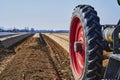 You look past a tractor at an asparagus field in Germany. The focus lies on the tire of the tractor, the horizon is somewhat out o Royalty Free Stock Photo