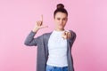 You are loser. Portrait of brunette teenage girl showing loser gesture and pointing at camera. on pink background