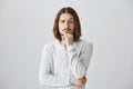 You made me interested and curious, tell details. Portrait of handsome young male with beard and long hair holding hand