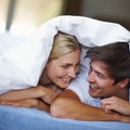 You, me and a blankie. a happy young couple enjoying a playful moment underneath the duvet. Royalty Free Stock Photo