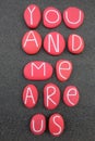 You and me are us, love message composed with red colored stones over black volcanic sand Royalty Free Stock Photo