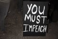 You Must Impeach sign at after dark rally with feet and shoes of protestors