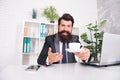 You need some caffeine. Happy hipster serve coffee in office. Director hold hot cup at desk. Caffeine energy. Caffeine