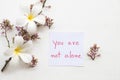 You are not alone message card handwriting with flower