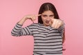 You are nuts! Portrait of woman in striped sweatshirt showing stupid gesture and pointing to camera