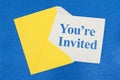 You`re Invited message on white card with a yellow envelope