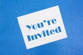 You`re Invited message on white envelope on blue