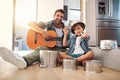 Are you ready for an encore. Portrait of a happy father accompanying his young son on the guitar while he drums on a set Royalty Free Stock Photo