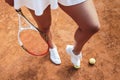 Are you ready to play? Cropped top view of a sporty young woman legs on clay tennis court with tennis balls on the ground. Sexy Royalty Free Stock Photo