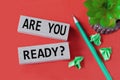 ARE YOU READY? - words on wooden bars on a red background with a handle, cactus and papers