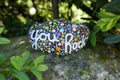 You rock encouraging message painted on kindness rock hidden in shadows