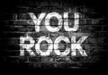 You rock lettering on brick wall. You Rock poster with grunge text design