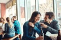 You say the funniest things. a young couple having drinks in a bar with people blurred in the background. Royalty Free Stock Photo