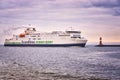 You see a big ferry going into the harbor of WarnemÃÂ¼nde when it passes a small lighthouse