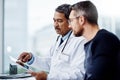 You see this is what my reports are telling me. a confident mature male doctor seated at his desk while consulting a Royalty Free Stock Photo