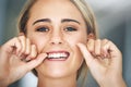 You should floss at least once a day. Portrait of an attractive young woman flossing her teeth in the bathroom. Royalty Free Stock Photo