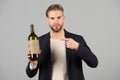 You should try this. Man holds bottle alcohol drink. Social and cultural aspects of drinking. Businessman formal suit Royalty Free Stock Photo