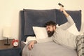 Although you sleep you may wake up feeling like did not sleep at all. Stages of sleep. Man awake unhappy with alarm Royalty Free Stock Photo