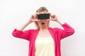 Are you sure? Portrait of shocked young woman in pink blouse standing, holding and covering eyes with smartphone, like eyeglasses Royalty Free Stock Photo
