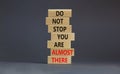 You are almost there symbol. Wooden blocks with words `do not stop you are almost there`. Beautiful grey background, copy space.