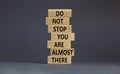 You are almost there symbol. Wooden blocks with words `do not stop you are almost there`. Beautiful grey background, copy space.