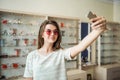 You think I should buy glasses or not. Portrait of glamourous attractive woman on shopping standing in optician store Royalty Free Stock Photo